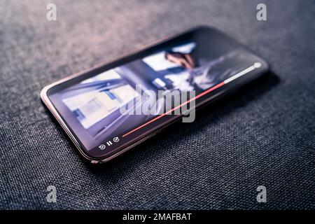 Movie stream or video player in mobile phone. Watching series online with smartphone concept. Film on demand service. Mockup VOD in screen. Stock Photo