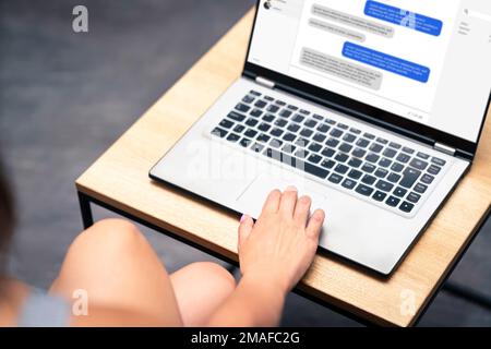 Chat messages in laptop. Online live help desk support for customers in computer screen. Talking business in web meeting in work office. Stock Photo