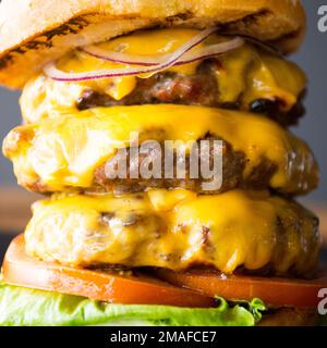 Tre hamburger con un tritare carne, verdure e formaggio su una piastra di  ferro, vista dall'alto Foto stock - Alamy