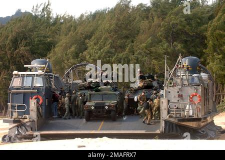 060722-N-9288T-131. [Complete] Scene Caption: A US Navy (USN) Landing Craft Air-Cushion (LCAC) craft disembarks US Marine Corps (USMC) Marines from 4th Light Armored Reconnaissance (LAR), Charlie Company (C CO) at a beach at Bellows Air Force Station (AFS), Hawaii (HI), during an amphibious assault training during Exercise Rim of the Pacific (RIMPAC) 2006. Also in the photo are USMC High Mobility Multipurpose Vehicles (HMMWV) and an Amphibious Assault Vehicle (AAV) being unloaded from the LCAC. The exercise designed to increase the tactical proficiency of participating units in a wide array of Stock Photo