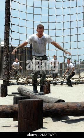 060727-N-9604C-265. [Complete] Scene Caption: 060727-N-9604C-265 (Jul. 27, 2006)Two US Navy Sea, Air, Land (SEAL) trainees make their way through an obstacle course during a demonstration for members of the National High School Coaching Association at the Basic Underwater Demolitions School at Naval Special Warfare Center (NSWC) located on Naval Amphibious Base (NAB) Coronado, California (CA). The NSWC hosted 24 high school coaches from across the US to showcase their special warfare and operations communities in an effort to encourage them to assist in recruiting dedicated and disciplined ind Stock Photo