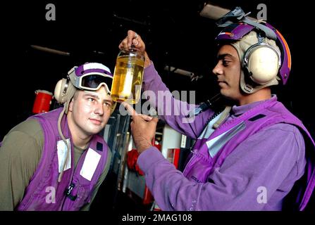 060813-N-5914D-006. [Complete] Scene Caption: 060813-N-5914D-006 (Aug. 13, 2006)US Navy (USN) Aviation Boatswain's Mate Fuels Third Class Rahim Panjwani (right) and US Marine Corps (USMC) Lance CPL. Gene Palmer, Bulk Fueler, Marine Medium Helicopter Squaron 165 (HMM-165) Reinforced (REIN), 15th Marine Expeditionary Unit (MEU), inspect the purity of jet fuel that will be used by aircraft aboard the USN Wasp Class Amphibious Assault Ship (LHD) USS BOXER (LHD 4). The 15th MEU and the BOXER are part of Expeditionary Strike Group 5 (ESG-5) which is currently participating in their Joint Task Force Stock Photo