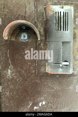 door peephole, security camera on an old shabby front door Stock Photo