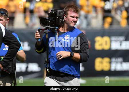 An NFL Films camera operator works during the first half of a