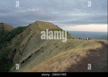 Group of tourist people on hike walking in volcano crater edge Stock Photo