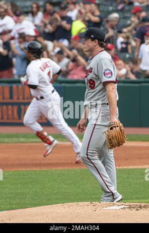 Minnesota Twins starting pitcher Josh Winder walks off the mound after  giving up a solo home run to Cleveland Guardians' Jose Ramirez, rounding  the bases in the background, during the first inning