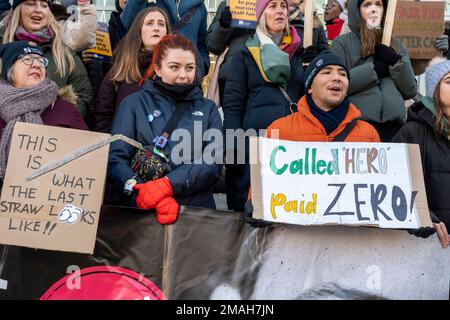 Nurses outside UCH Hospital, London striking for more pay and staff with placards "Called Hero, paid Zero", "This is what the last straw looks like". Stock Photo