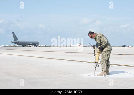 (220526-N-OI810-0595) KEY WEST, Florida (May 26, 2022) Steelworker 1st Class Leonardo Gomez, from Bogota, Colombia, assigned to Naval Mobile Construction Battalion (NMCB) 14, uses a demolition hammer to break up a damaged section of runway at Boca Chica Field, Naval Air Station Key West (NASKW), May 26, 2022. NMCB-14 teamed up with NASKW Public Works and NASKW Air Operations Department to complete the needed airfield damage repair. Seabees assigned to NMCB-14 travelled to NASKW to perform on-site training and assist with facility and compound maintenance. NMCB-14 provides advance base construc Stock Photo