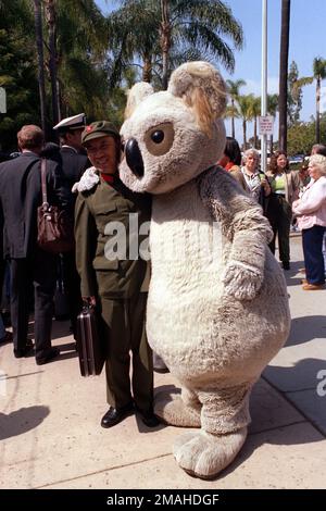 A member of the Chinese delegation from the People's Republic of China is hugged by a person dressed in a koala bear suit at the zoo. Base: San Diego State: California (CA) Country: United States Of America (USA) Stock Photo