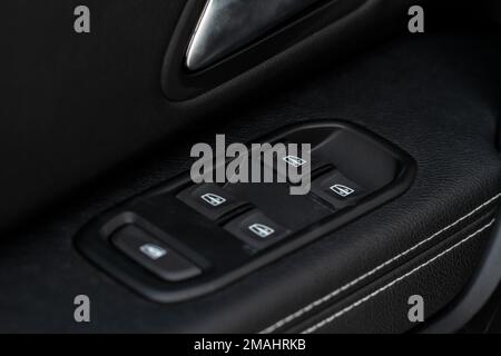 Window control buttons in modern car. Car window control panel. Modern car window switch. Door handle with power window control. Stock Photo