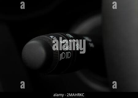 Modern car light switch. Turning on headlight in the car. Close up of car light control. Stock Photo