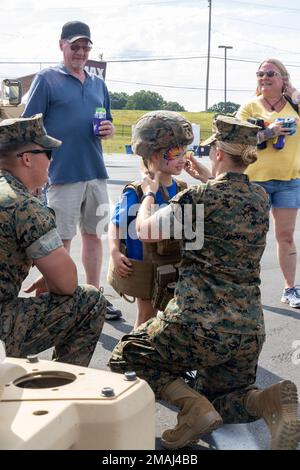 U.S. Marines with Truck Company, Headquarters Battalion, 2nd Marine Division, place gear on an attendee at The NASCAR Coca-Cola 600, Charlotte Motor Speedway's Memorial Day race in Charlotte, North Carolina, May 27, 2022. Attendees had the opportunity to wear gear and stand with Marines in front of Joint Light Tactical Vehicle during the NACSAR events. Stock Photo