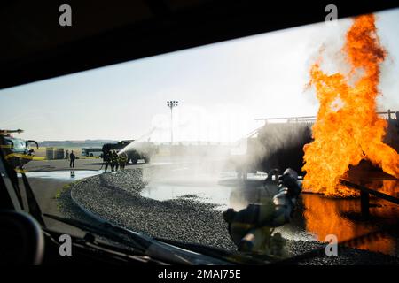 Aircraft rescue and firefighting Marines with Headquarters and Headquarters Squadron, Marine Corps Air Station (MCAS) Iwakuni, spray a fire during aircraft rescue firefighting training on MCAS Iwakuni, Japan, May 27, 2022. Marines conduct this live-fire training monthly to ensure readiness in the case of any aircraft emergency. Stock Photo