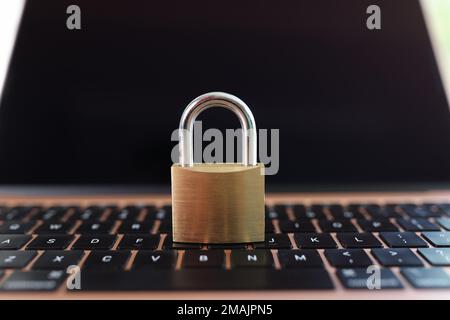 Metal padlock on laptop keyboard close-up. Stock Photo