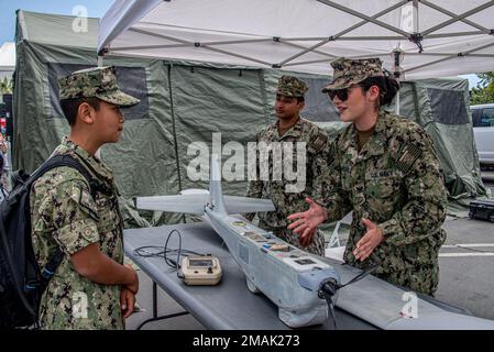 220529-N-NT795-851 SAN PEDRO, Calif. (May 29, 2022) Electronics Technician 2nd Class Stephana Sanchez, native of Denver, Colorado, and assigned  to Maritime Expeditionary Security Group (MESG) 1, speaks with a Sailor at the Los Angeles Fleet Week Expo. LAFW is an opportunity for the American public to meet their Navy, Marine Corps and Coast Guard team and expedience America’s sea services. During fleet week, service members will participate in various community service events, display capabilities and equipment to the community, and enjoy the hospitality of Los Angeles and the surrounding area Stock Photo