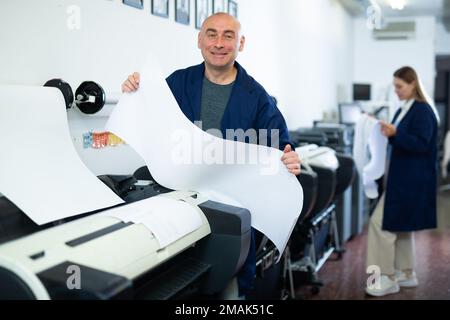 Man working in publishing facility Stock Photo