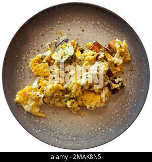 Tasty scrambled eggs with bacon on plate served with cutlery Stock Photo