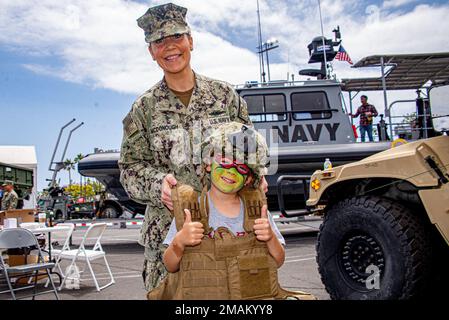 220529-N-NT795-851 SAN PEDRO, Calif. (May 29, 2022) Chief Yeoman Sarah McDonough, a native of Dubuque, Iowa, and assigned to Maritime Expeditionary Security Group (MESG) 1, poses for a photo with a guest during the Los Angeles Fleet Week Expo. LAFW is an opportunity for the American public to meet their Navy, Marine Corps and Coast Guard team and expedience America’s sea services. During fleet week, service members will participate in various community service events, display capabilities and equipment to the community, and enjoy the hospitality of Los Angeles and the surrounding areas to offe Stock Photo