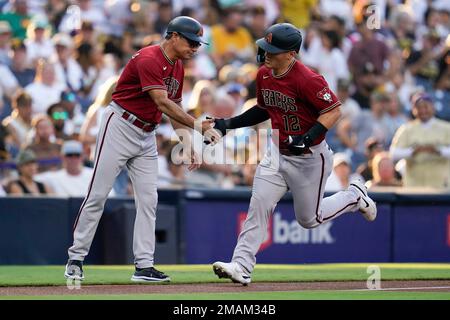 Arizona Diamondbacks' Buddy Kennedy, right, is congratulated by third base  coach Tony Perezchica after hitting an RBI triple against the San Diego  Padres in the fourth inning of a baseball game, Saturday