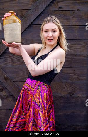 On a very cold winters day in Dundee a beautiful and fashionable woman Hayleigh Young holds an 1800's ale flagon near the RRS Discovery ship, Scotland Stock Photo