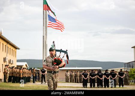 A British Army Soldier, assigned to Charlie Company, 1st Battalion, The Royal Irish Regiment, plays the bagpipe as Soldiers from the U.S. Army, British Army, and Bulgarian Land Forces stand in formation in honor of those who have made the ultimate sacrifice in service to their nation during a Memorial Day Ceremony at Novo Selo Training Area, Bulgaria, May 30, 2022. Stock Photo