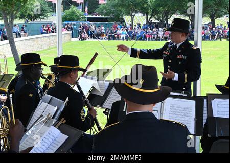 The U.S. Army 1st Cavalry Division Band at Fort Hood, Texas, performs for hundreds of visitors at the Dallas-Fort Worth National Cemetery’s wreath-laying ceremony May 30, 2022. Stock Photo