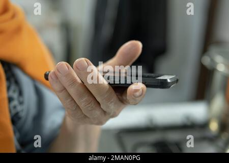 Elderly woman hand view while holding a smartphone, senior health care and technology lifestyle Stock Photo