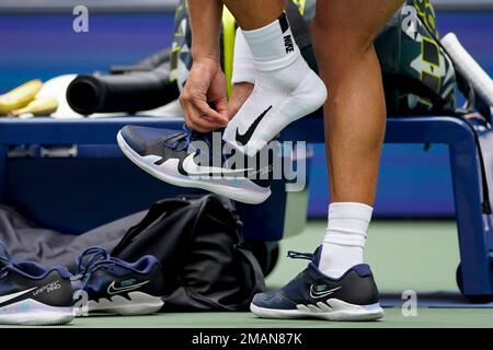 Carlos Alcaraz, of Spain, changes his shoes during a break in play