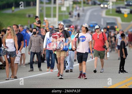 Spectators watch a sunrise from the Max Brewer Bridge while waiting to view  the launch on Pad 39B for the Artemis I mission to orbit the moon at the  Kennedy Space Center