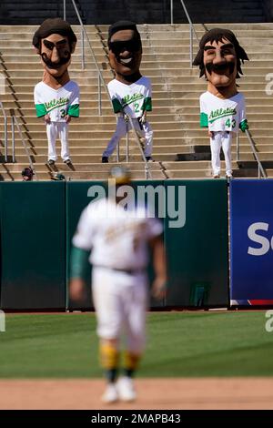 Mascots representing former Oakland Athletics Rollie Fingers, from left,  Rickey Henderson and Dennis Eckersley wait before racing during a baseball  game between the Athletics and the New York Yankees in Oakland, Calif.,  Sunday, Aug. 28, 2022. (AP