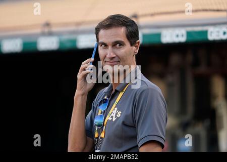 Oakland Athletics president Dave Kaval, left, talks to Reggie