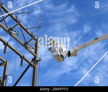 Contractors test voltage using “hot sticks” atop a lift at substation N on Vandenberg Space Force Base, Calif., June 2, 2022. Power is routed to the substation using a phasing system, and to make sure the phases are in sync, voltage has to be measured using hot sticks. SLD 30,South Loop Two,U.S. Space Force,VSFB,Vandenberg Space Force Base,civil engineers, Stock Photo