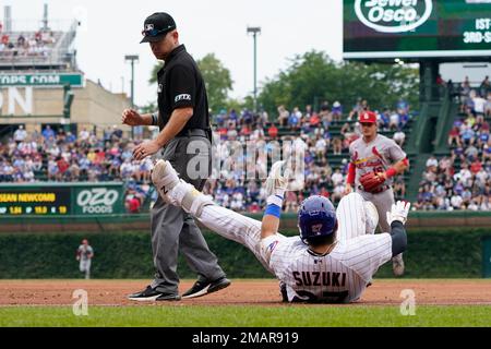 Chicago Cubs' Seiya Suzuki, left, is congratulated by first base coach Mike  Napoli after hitting a single against the San Francisco Giants during the  eighth inning of a baseball game in San