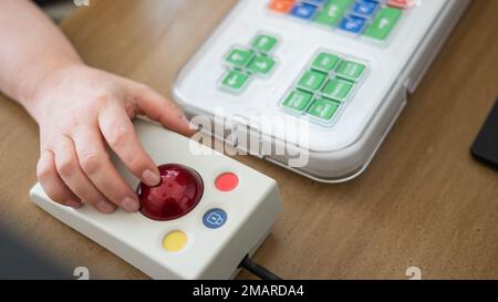 Woman with cerebral palsy works on a specialized computer mouse. Stock Photo