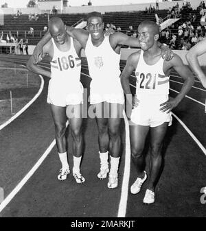 Bob Hayes, center, of Florida A&M, puts his arms around two of his