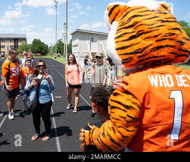 A mother takes a picture of her child posing with Who Dey, the Cincinnati Bengals’ mascot, at the USO-sponsored Bengals’ skill clinic June 6, 2022, at Wright-Patterson Air Force Base, Ohio. Wright-Patt kids got the chance to learn football skills from Bengals rookies. Stock Photo