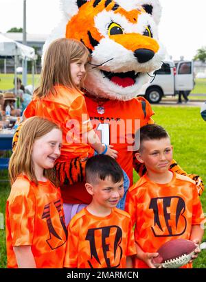 The Kulesza children, (counterclockwise from top) Violet, Madison, Victor and Steven, pose with Who Dey, the Cincinnati Bengals’ mascot, after a USO-sponsored Bengals’ skill clinic June 3, 2022, at Wright-Patterson Air Force Base, Ohio. Who Dey joined a group of Bengal rookies in working with 99 Wright-Patt children on their football skills. Stock Photo
