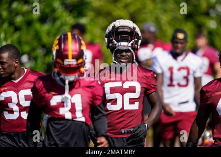 Washington Football Team first round draft pick, linebacker Jamin Davis  (52) and defensive end Chase Young (99) talk during an NFL football  practice at Inova Sports Performance Center in Ashburn, Va., Wednesday