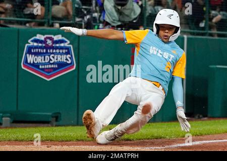 Honolulu, Hawaii's Rustan Hiyoto, left, scores on a wild pitch by Bonney  Lake, Washington's Luke Plyler, right, during the fifth inning of a baseball  game at the Little League World Series in