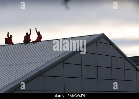 Edinburgh, UK. 19th Jan, 2023. Protesters raise their fists in defiance as Palestinian Activists sit on the ridge of the roof during the protest. Palestine Activists cut the security fence in the dead of the night and get on the roof of arms factory Leonardo in Edinburgh. They are protesting and highlighting the fact that Leonardo are providing laser guidance systems for Israeli F35 combat aircraft and Hermes 450 drones. These munitions are used against the Palestinian people in Gaza and elsewhere. Credit: SOPA Images Limited/Alamy Live News Stock Photo