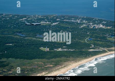 A KC-46A Pegasus assigned to the 916th Air Refueling Wing at Seymour Johnson Air Force Base, North Carolina, flies over a lighthouse off the coast of North Carolina, June 6, 2022. Depending on fuel storage configuration, the aircraft can carry a palletized load of up to 65,000 pounds of cargo. Stock Photo