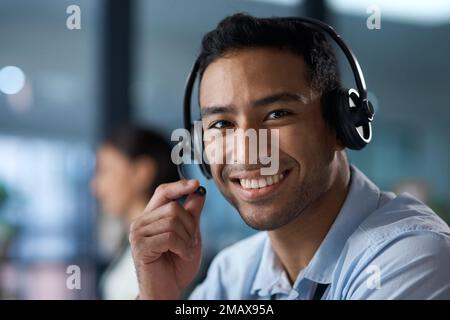 You want it, well do it. Portrait of a young man using a headset in a modern office. Stock Photo