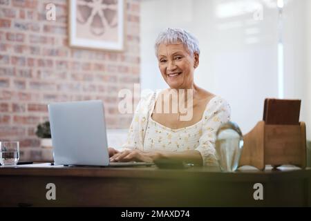 Who said you need to settle down at 70. a senior woman using a laptop at home. Stock Photo