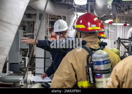 SASEBO, Japan (June 7, 2022) Chief Damage Controlman Jeffery Davis, from Cherry Valley, Ill., assigned to the forward-deployed amphibious assault ship USS America (LHA 6), trains Sailors, also assigned to America, during a damage control exercise in one of the ships engine rooms. America, lead ship of the America Amphibious Ready Group, is operating in the U.S. 7th Fleet area of responsibility to enhance interoperability with allies and partners and serve as a ready response force to defend peace and stability in the Indo-Pacific region. Stock Photo
