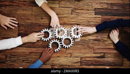 Hands Holding Interlocked Gear Wheels. Business Partnership Stock Photo