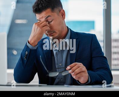 This is an actual nightmare. a handsome young businessman sitting alone in the office and feeling stressed while using his laptop. Stock Photo