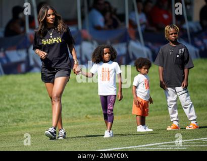 Denver Broncos quarterback Russell Wilson (3) greets, from left to right,  his daughter Sienna, wife and rap star Ciara, and sons Future and Win  before taking part in drills during the NFL