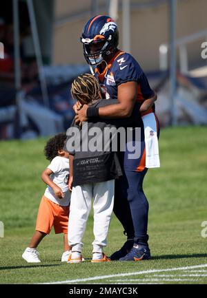 Denver Broncos quarterback Russell Wilson (3) greets, from left to right,  his daughter Sienna, wife and rap star Ciara, and sons Future and Win  before taking part in drills during the NFL