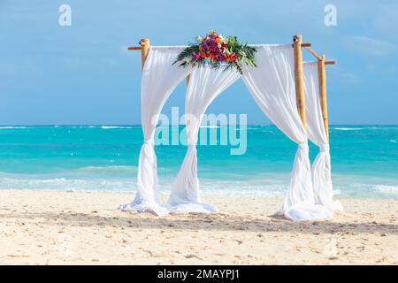 Empty Marriage gazebo with white curtains and flowers decoration is on a sandy beach, Dominican Republic, Bavaro beach Stock Photo