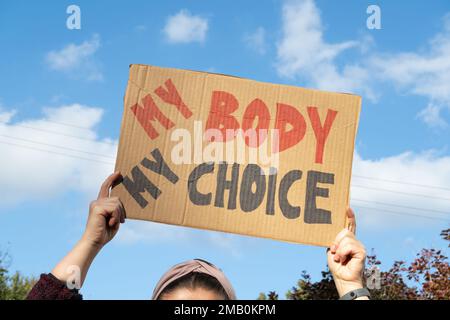 Woman holding placard sign with slogan My Body My Choice during manifestation. Female protester with banner at protest rally demonstration. Stock Photo